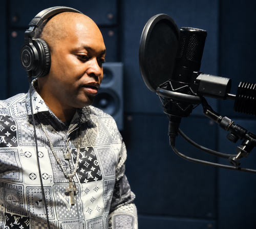 EveryoneLovesIce recording vocals in a professional studio booth